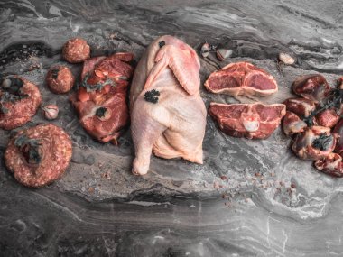 Taze çiğ et. Çiğ domuz eti farklı, tavuk, sığır eti, koyu mermer otlar ile hindi sakatlar, kopya alanı