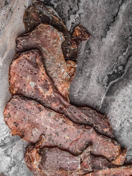 Pezzi di carne marmorizzata essiccata, fette disidratate in spezie salate, copiare spazio — Foto Stock
