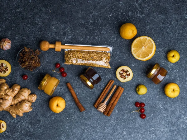 Stock image Natural flu and cold remedy ingredients, chamomile flowers, cinnamon sticks, ginger, lemon, honey, cydonia, propolis, garlic Flat lay.