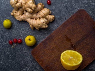 zencefil kökü, ahşap tahta üzerinde limon, cydonia, gri arka plan üzerinde kırmızı çilek