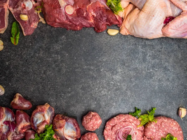 Carne cruda surtida sobre fondo oscuro. Diferentes tipos de carne y alimentos procesados. Vista superior, imagen tonificada vintage, espacio en blanco — Foto de Stock