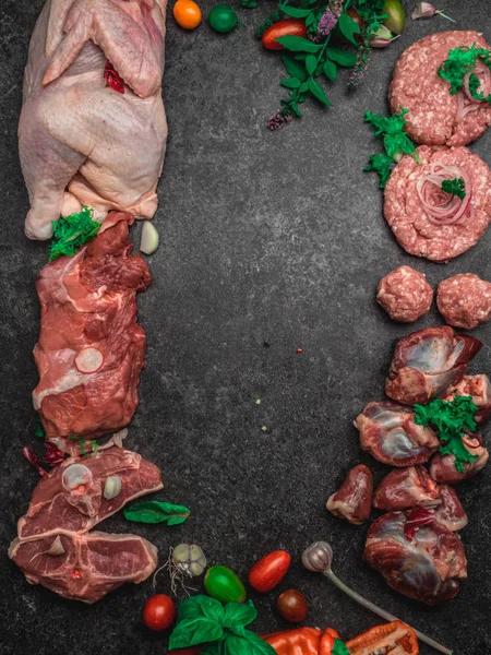 Carne cruda surtida sobre fondo oscuro. Diferentes tipos de carne y alimentos procesados. Vista superior, imagen tonificada vintage, espacio en blanco — Foto de Stock