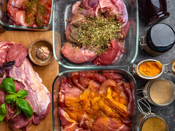 Fundo de carne crua. com uma variedade de ervas e especiarias. Na mesa de betão cinzento . — Fotografia de Stock