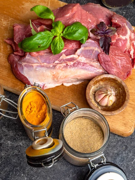 Carne crua com especiarias em jarros de vidro, manjericão fresco, alho de perto — Fotografia de Stock