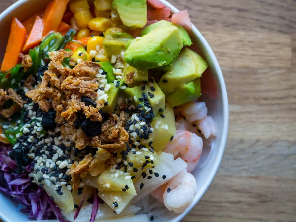 Plato tradicional hawaiano, con mariscos, fideos, semillas, aguacate, piña, cebolla, ensalada, con salsas, sobre fondo de madera — Foto de Stock