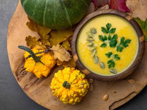 Cuenco de sopa de lentejas, zanahoria y calabaza con semillas, perejil, decorado con follaje de otoño — Foto de Stock