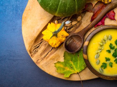 Krema lı kabak, havuç, kabak çekirdeği ile mercimek çorbası, tahta kasede maydanoz, dekoratif kabak ve sonbahar yaprakları