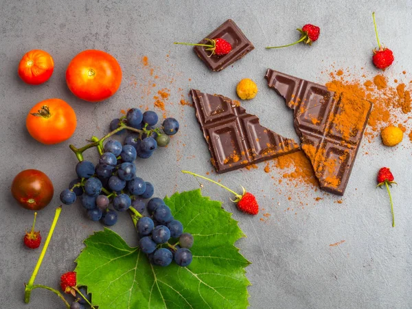 Alimentos anticancerígenos, bom para o sistema de chaleiras, uva madura fresca, chocolate escuro, framboesas, tomates, maçã em fundo de concreto. Alimentos ricos em resveratrol, antioxidantes — Fotografia de Stock