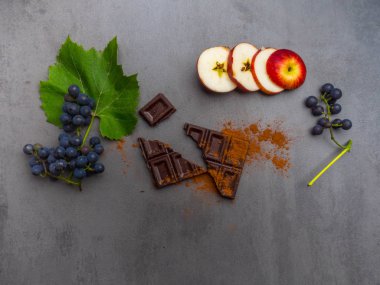 koyu çikolata, taze üzüm, elma dilimleri, beton arka plan üzerinde kakao tozu, antioksidanlar, resveratrol zengin gıda