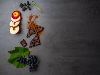 koyu çikolata, taze üzüm, elma dilimleri, beton arka plan üzerinde kakao tozu, antioksidanlar, resveratrol zengin gıda