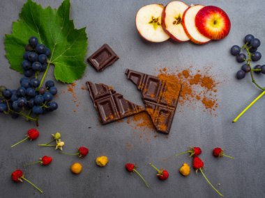 antikanser gıda, kardiyovaskülsistemi için iyi, taze olgun üzüm, ahududu, koyu çikolata, kakao, beton arka plan üzerinde elma dilimleri. Gıda resveratrol açısından zengin, antioksidanlar