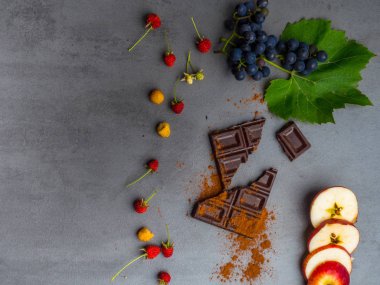 antikanser gıda, kardiyovaskülsistemi için iyi, taze olgun üzüm, ahududu, koyu çikolata, kakao, beton arka plan üzerinde elma dilimleri. Gıda resveratrol açısından zengin, antioksidanlar