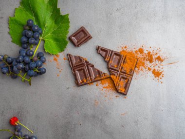 Koyu çikolata, taze ahududu yığını ile kakao, gri arka plan üzerinde üzüm. Resveratrol zengin gıda