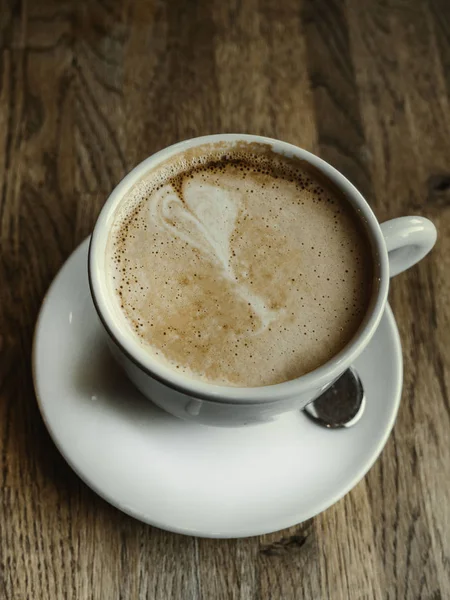 Xícara de café de arte quente latte na mesa de madeira — Fotografia de Stock