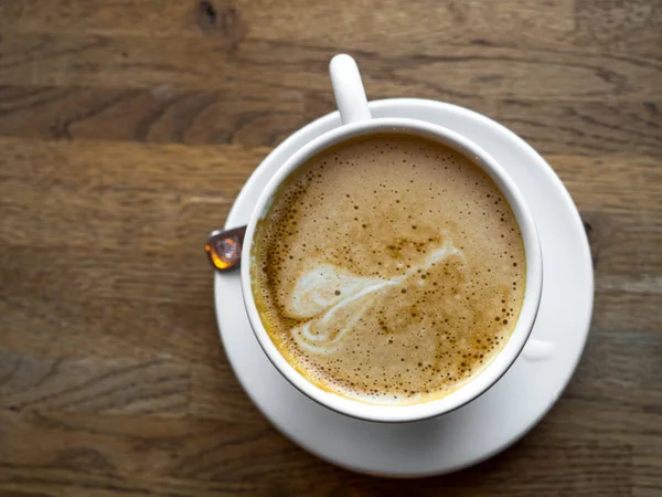 Secangkir kopi latte panas di atas meja kayu — Stok Foto