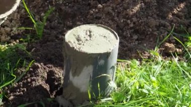 Beton silindirli boru cemente, iş eldivenli işçi, bir mala macunu bıçağı, spatula ile inşa eden, boruda beton havan deliği ile kaplı, bir inşaat sahasında, endüstri konsepti