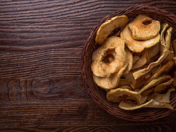 Top view of bowl with dried apple chips on wooden table — Stock Photo, Image