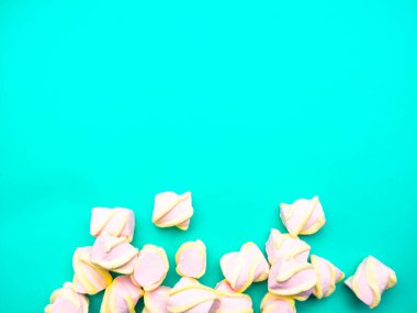 Telif alanı ve üst görünümü olan mavi arkaplanda şekerlemeler. Renkli mini marşmelovların arka planı ya da dokusu. Kış yemekleri konsepti.