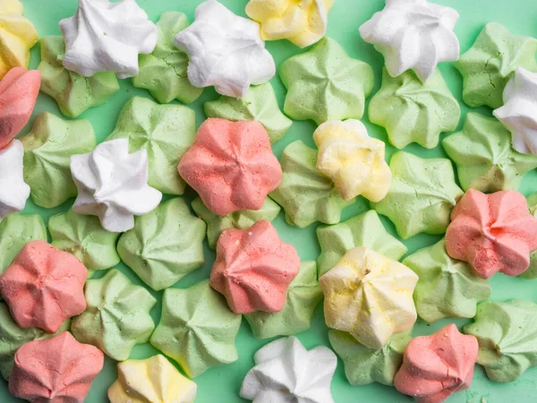 Heerlijke kleurrijke merengues, Trendy top view dessert afbeelding. Roze, groene munt, geel, wit kleine zelfgemaakte snoepjes — Stockfoto