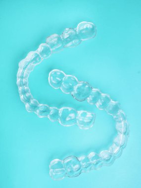 Görünmez diş dişleri mavi arka plan üzerinde diş hizalayıcılar braketler, plastik parantez diş hekimliği tutucular dişleri düzeltmek için. Diş hekimi ofis diş hekiminde ortodontik geçici çıkarılabilir düzleştiriciler