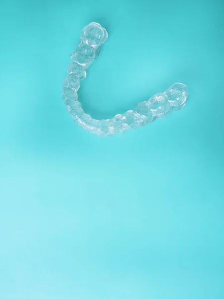 Aligners dentários invisíveis suportes dentários modernos em fundo azul, aparelhos transparentes para alisar os dentes na odontologia estética e ortodontia — Fotografia de Stock