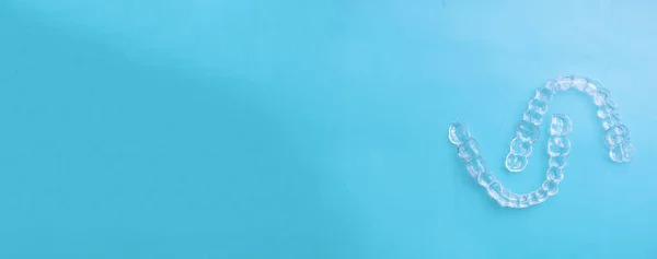 Görünmez diş dişleri mavi arka plan üzerinde diş hizalayıcılar braketler, plastik parantez diş hekimliği tutucular dişleri düzeltmek için. Diş hekimi ofis diş hekiminde ortodontik geçici çıkarılabilir düzleştiriciler