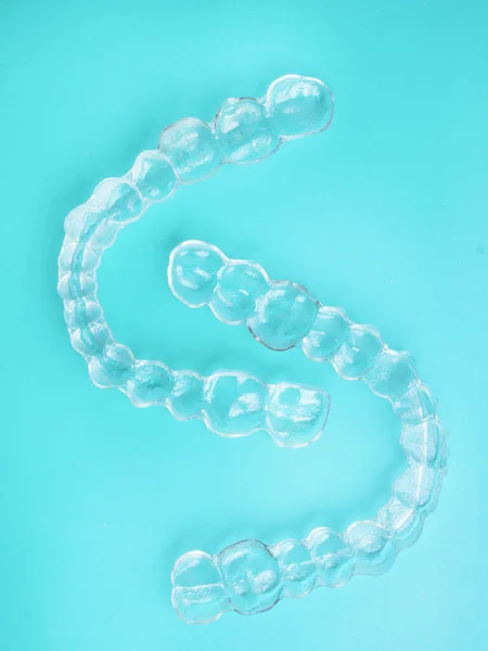 Invisible dental teeth brackets tooth aligners on blue background, plastic braces dentistry retainers to straighten teeth. Orthodontic temporary removable straighteners in dentist office dental — Stock Photo, Image