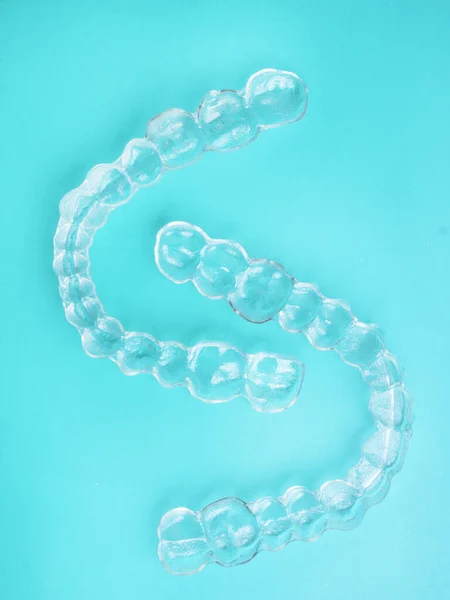 Görünmez diş dişleri mavi arka plan üzerinde diş hizalayıcılar braketler, plastik parantez diş hekimliği tutucular dişleri düzeltmek için. Diş hekimi ofis diş hekiminde ortodontik geçici çıkarılabilir düzleştiriciler