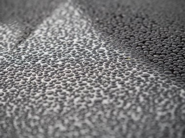 Koyu cam zemin üzerine yağmur damlalarının seçici odak noktası