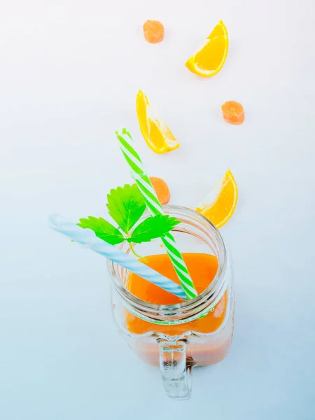 緑の葉を持つ新鮮なニンジンとオレンジジュース ガラス瓶のスムージー 抗酸化物質とビタミンデトックスドリンク コピースペース サイドビュー — ストック写真