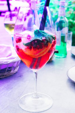 Nane, limon dilimleri ve kırmızı böğürtlenli yaz kokteyli, yaz ferahlatıcı içecek. Böğürtlen kokteyli, ferahlatıcı kırmızı içki, mojito. Neon renginde yaratıcı ton