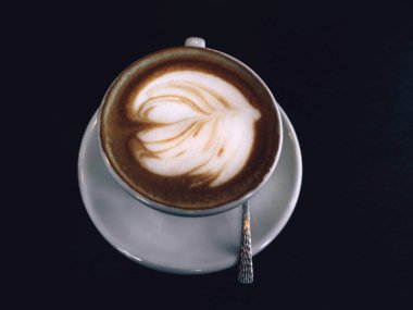 Bir fincan sıcak latte ya da köpüklü kapuçino. Moda tonu. Minimum bileşim. Üst manzara, düz yatak, yakın çekim.