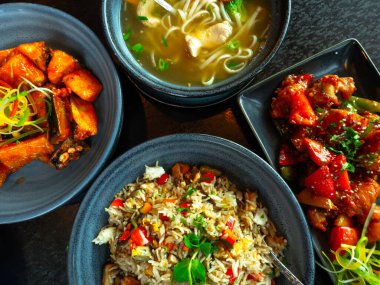 çeşitli geleneksel Çin ya da Hint mutfağı yemekleri, vejetaryen ya da vejetaryen restoran yemekleri, tavuk çorbası, pilav, patlıcan, seramik kaseler. Sağlıklı doğu yerel yiyecek çeşitleri. Seçici odak