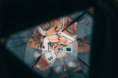 50 Euro nakit banknotta büyüteç kaleydoskop. Avrupa parası, sahte para, para birimi, borç, ekonomi ve finansal analiz kavramı, yaratıcı tonlama