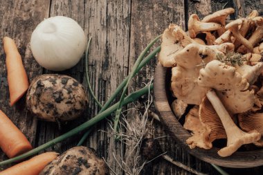 Lezzetli vejetaryen chanterelles mantar çorbası, soğan, havuç, kırsal ahşap arka planda patates.