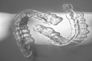 Modern diş saydam hizalayıcılar veya kozmetik dişçilikte dişleri düzeltmek için diş telleri ve moda çiçek gölgeleriyle ortodonti, seçici odak