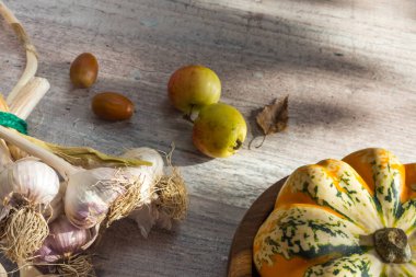 Balkabaklarından sonbahar dekoru, beyaz ahşap arka planda kırmızı böğürtlen sarımsağı. Şükran Günü veya Cadılar Bayramı kavramı. Düz sonbahar kompozisyonu