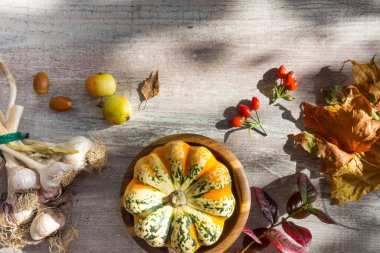 Balkabaklarından sonbahar dekoru, beyaz ahşap arka planda kırmızı böğürtlen sarımsağı. Şükran Günü veya Cadılar Bayramı kavramı. Düz sonbahar kompozisyonu