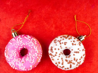 Kırmızı arka planda renkli Noel çörekleri, kış tatili konsepti, kopyalama alanı