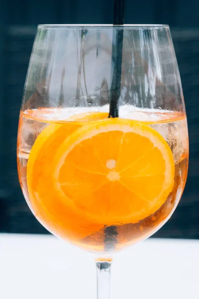 氷のキューブとオレンジのスライスとアルコールアペロルスピッツカクテルのガラス クラシックなイタリアのトレンディーなカクテルドリンク 暗い背景 選択的な焦点 — ストック写真