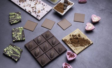 Çeşitli renklerde çikolatalar. Çeşitli siyah süt beyaz çikolata koleksiyonunun tatlıları. Tatlı, tatlı gerçekçi atıştırmalık. Seçici odak