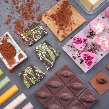 Çeşitli renklerde çikolatalar. Çeşitli siyah süt beyaz çikolata koleksiyonunun tatlıları. Tatlı, tatlı gerçekçi atıştırmalık. Seçici odak