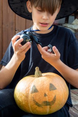 Cadılar bayramı şapkalı çocuk ellerinde balkabağı ve balkabağı, komik zaman, dışarıda Cadılar Bayramı tatili hazırlıkları