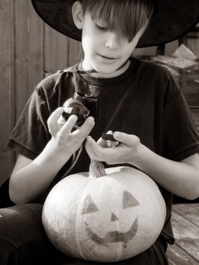 Cadılar bayramı şapkalı çocuk ellerinde balkabağı ve balkabağı, komik zaman, dışarıda Cadılar Bayramı tatili hazırlıkları