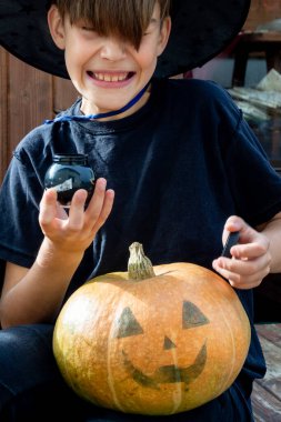 Cadılar bayramı şapkalı çocuk ellerinde balkabağı ve balkabağı, komik zaman, dışarıda Cadılar Bayramı tatili hazırlıkları