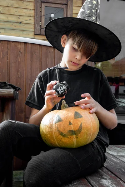 Cadılar bayramı şapkalı çocuk ellerinde balkabağı ve balkabağı, komik zaman, dışarıda Cadılar Bayramı tatili hazırlıkları