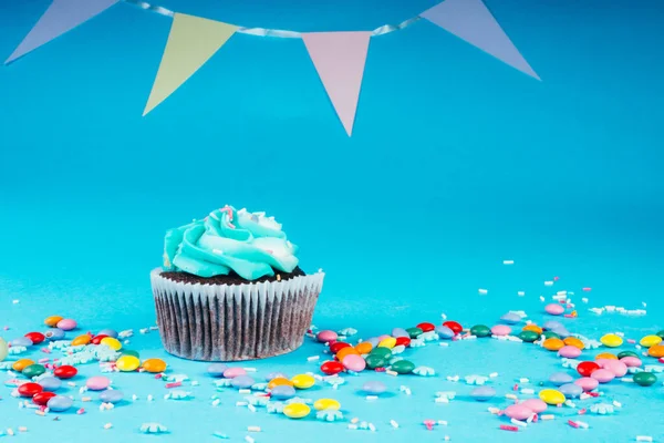 Cupcake Mit Schlagsahne Vor Blauem Hintergrund Dekoriert Mit Zuckerschneeflocken Streusel — Stockfoto