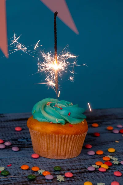 Geburtstag Oder Weihnachten Leckerer Cupcake Mit Wunderkerze Vor Blauem Hintergrund — Stockfoto