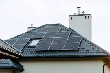 Güneş panelleri güneş ışığını çatıda yakalıyor, sürdürülebilir enerjiyi ve çevre dostu yaşamı sembolize ediyor