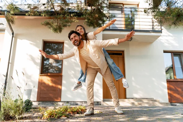 Mutlu bir baba kızını sırtında taşır, modern evlerinin önünde uçar gibi oynarlar, ailecek vakit geçirirler. Babalık kavramı